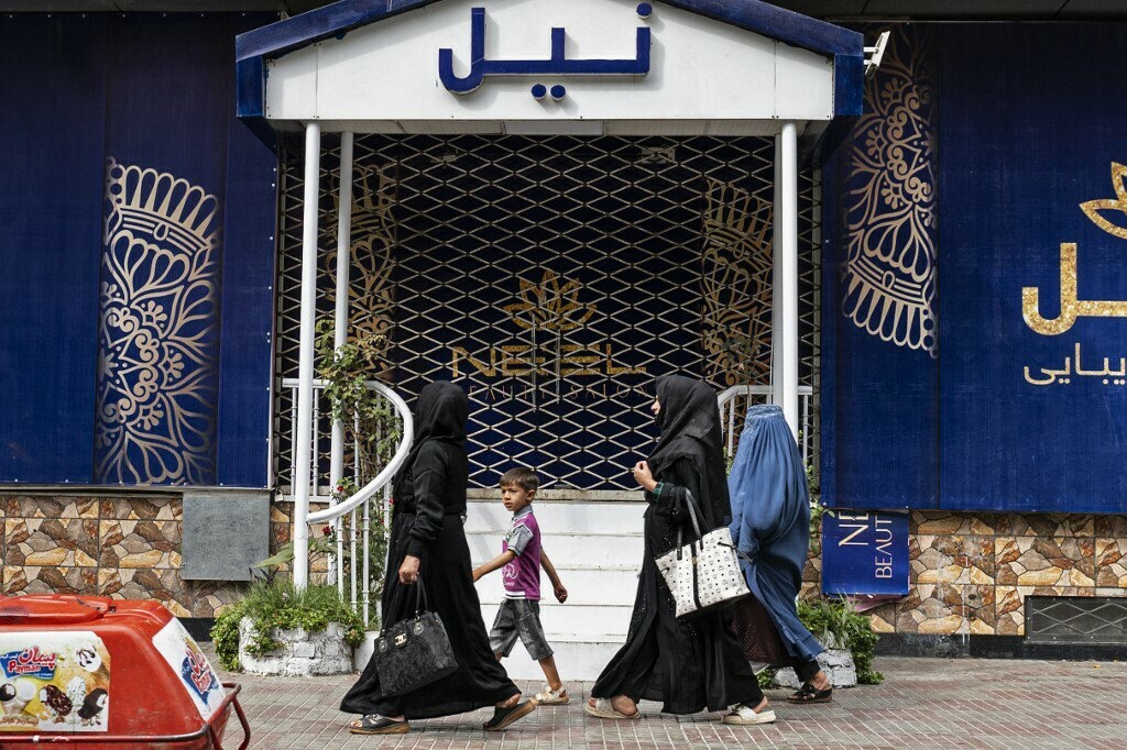 Afghan women walks past a closed beauty parlour in Kabul on July 25, 2023. Afghanistan’s Taliban authorities have ordered beauty parlours across the country to shut within a month, the vice ministry confirmed the latest curb to squeeze women out of public life. Photo: AFP