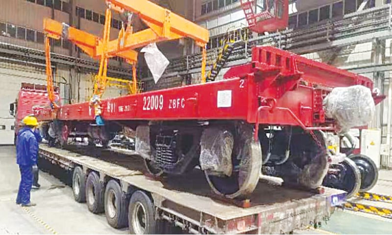 CHINESE firm officials clear a completely built unit of flat wagon for shipment to Pakistan.—Courtesy PR