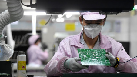 An employee inspects a circuit board on the controller production line at a Gree factory, following the coronavirus disease (Covid-19) outbreak in Wuhan, Hubei province, China August 16, 2021. Photo :Reuters