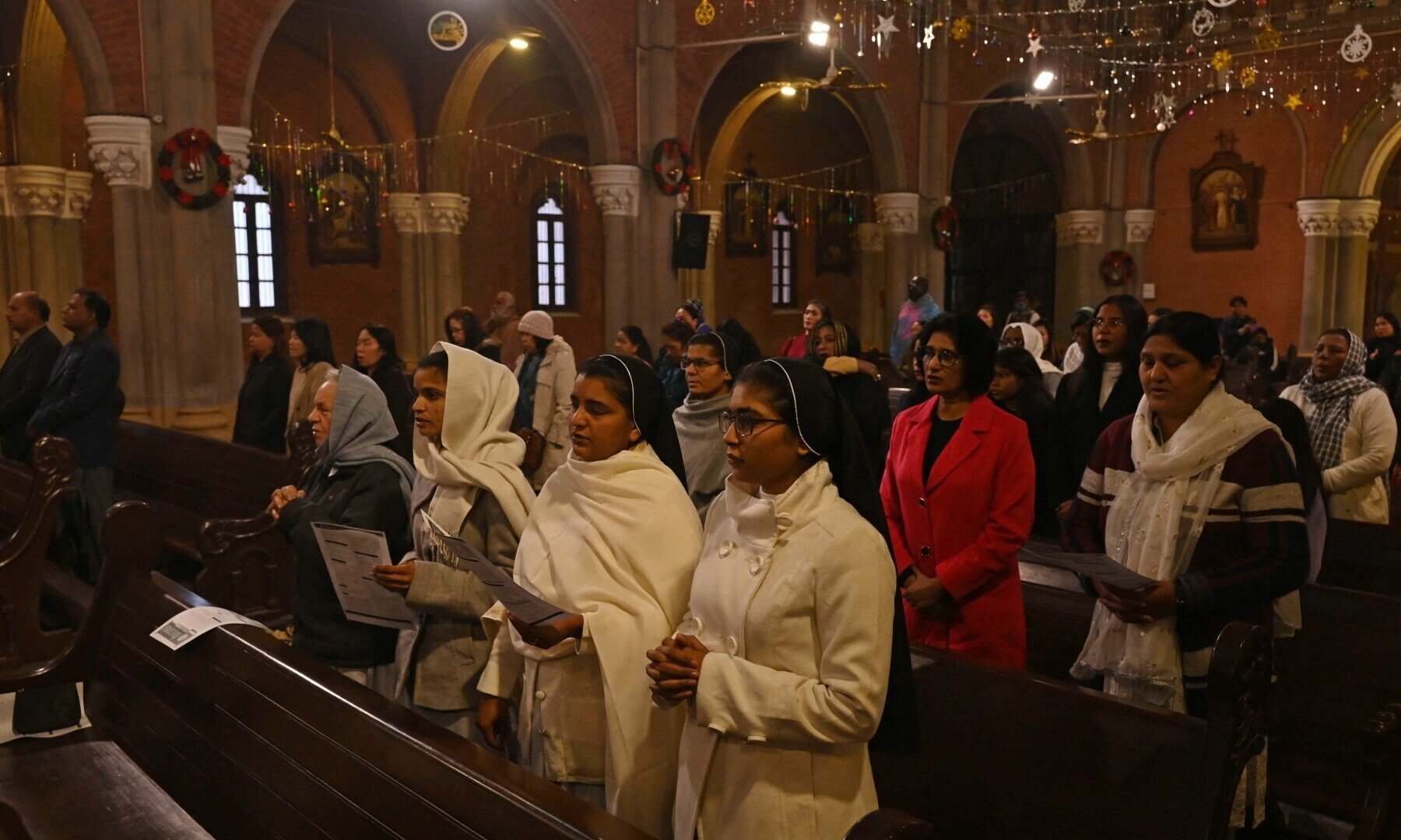 Christian devotees take part in a Christmas prayer service at the Sacred Heart Cathedral in Lahore on December 25, 2022. — AFP