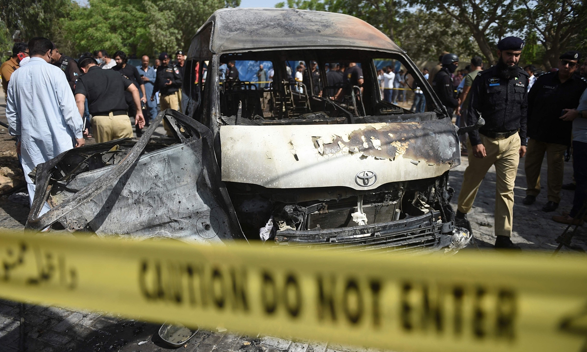 Police inspect a site around damaged vehicles following a suicide bombing near the Confucious Institute affiliated with the Karachi University, in Karachi on April 26, 2022. Photo:VCG