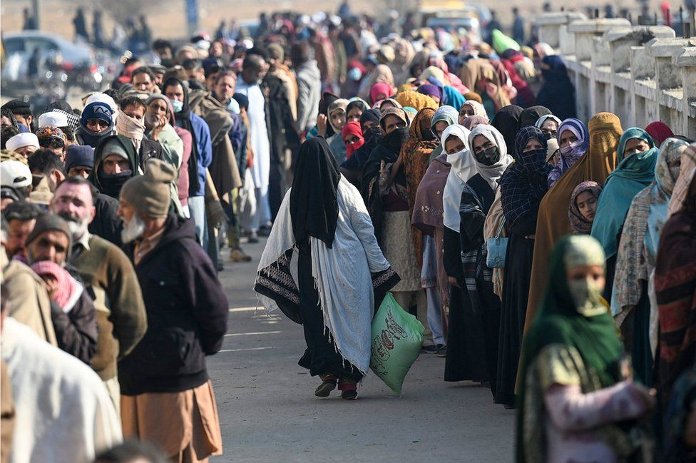 Local residents queue to buy wheat flour at government-controlled prices in Islamabad on January 10, 2023.