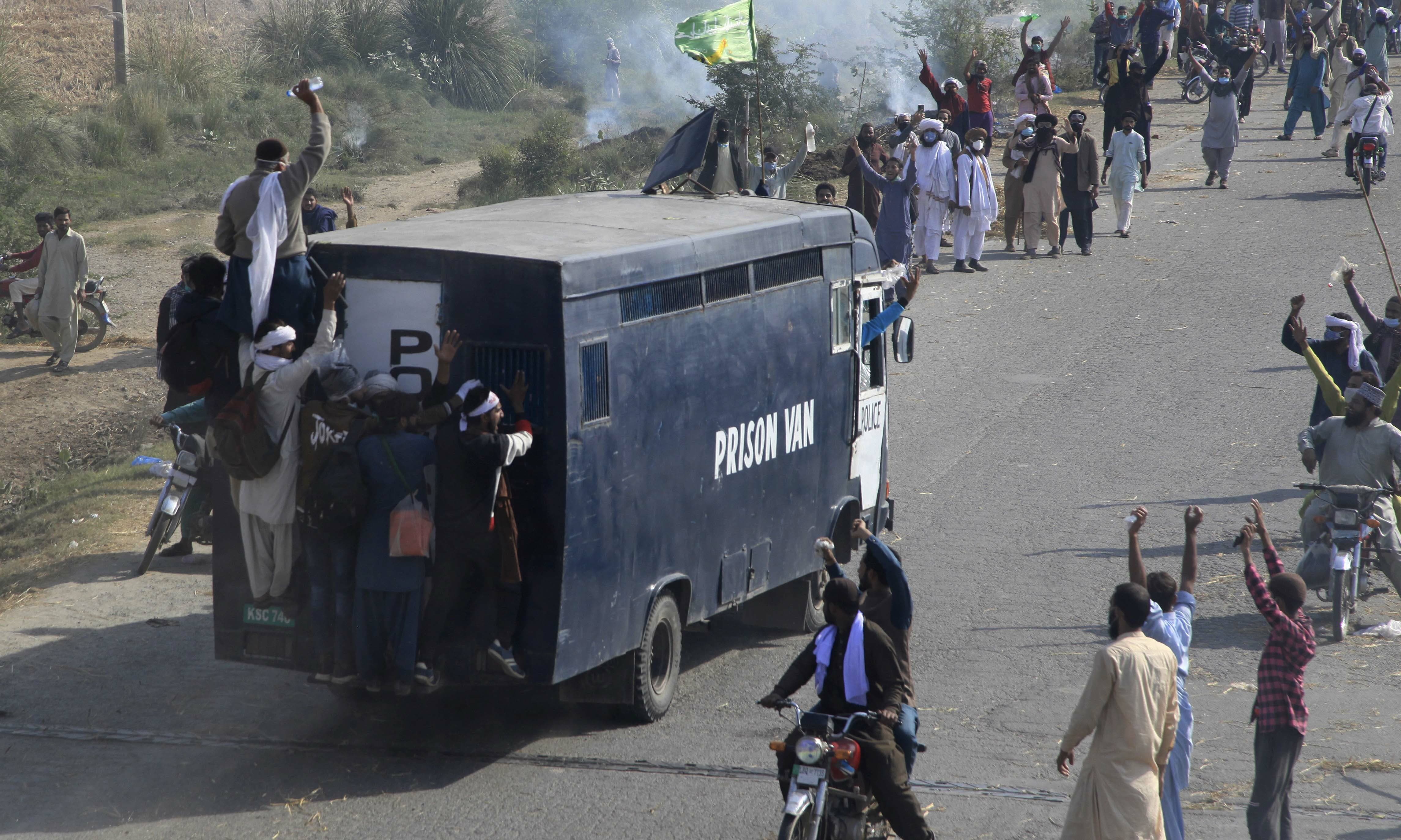 Tehreek-i-Labbaik Pakistan supporters celebrate after capturing a police vehicle during their protest march toward Islamabad, on a highway in the town of Sadhoke on Wednesday. — AP