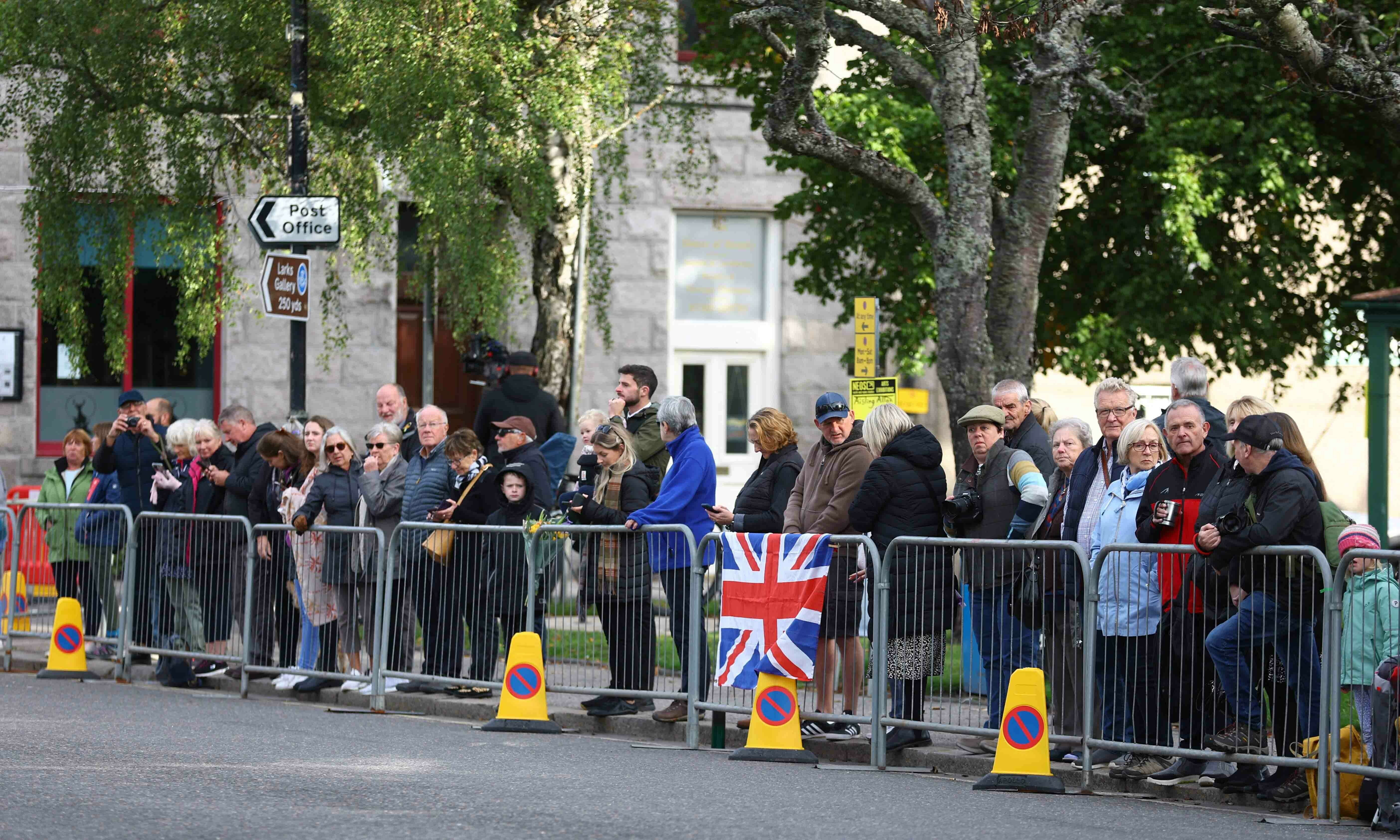 <p>People line the street waiting for the funeral cortage carrying Britain’s Queen Elizabeth in the village of Ballater, following the Queen’s passing, near Balmoral, Scotland on September 11. — Reuters</p>