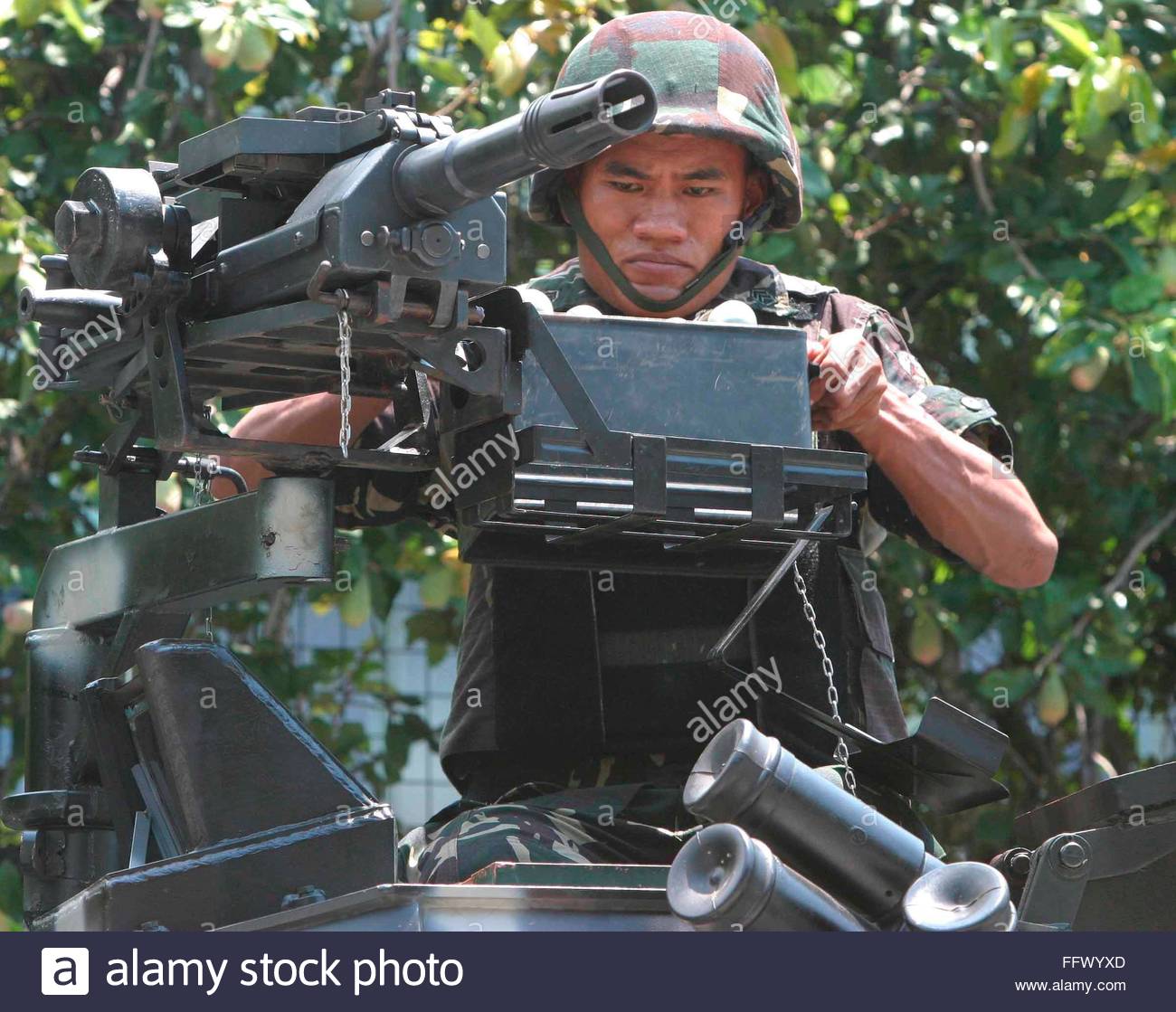 a-filipino-soldier-loads-ammunition-for-a-machine-gun-on-top-of-an-FFWYXD.jpg