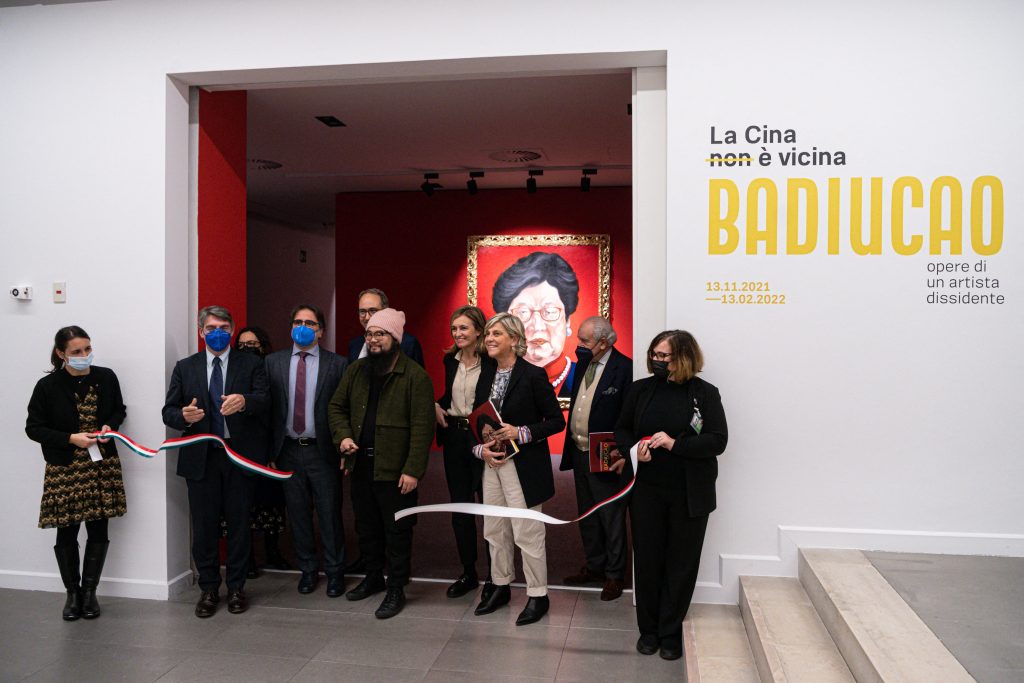 Chinese dissident artist Badiucao (C), with Mayor of Brescia, Emilio Del Bono (2ndL), vice-Mayor of Brescis, Laura Castelletti (3rdR), President of Fondazione Brescia Musei, Francesca Bazoli (4thR), cuts the ribbon on the opening of an exhibition of his artworks on November 12, 2021 entitled China is (not) near -- works of a dissident artist, at the Santa Giulia museum in Brescia, Lombardy. Photo by Piero Cruciatti/AFP via Getty Images.