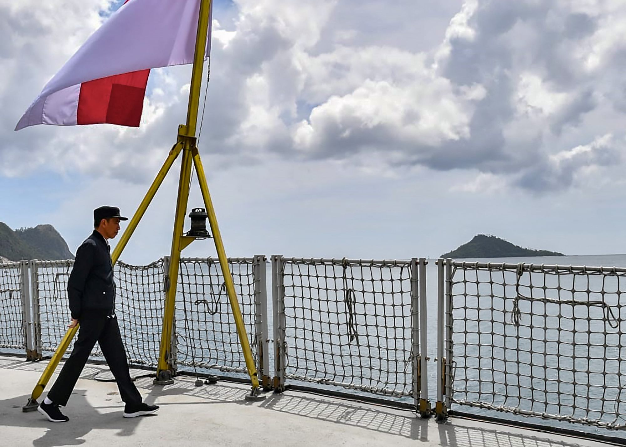 Indonesia’s President Joko Widodo walks past the country’s flag on a navy ship during his visit to a military base in the Natuna Islands, which border the South China Sea. Photo: Presidential Palance/AFP
