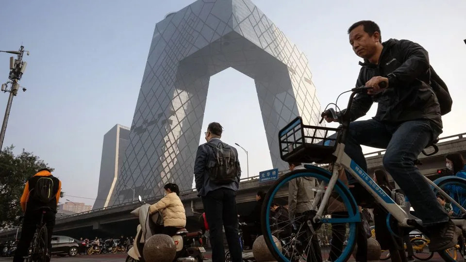 Morning commuters pass the CCTV tower in Beijing, China, on Monday, Oct. 30, 2023. - Stringer/Bloomberg/Getty Images