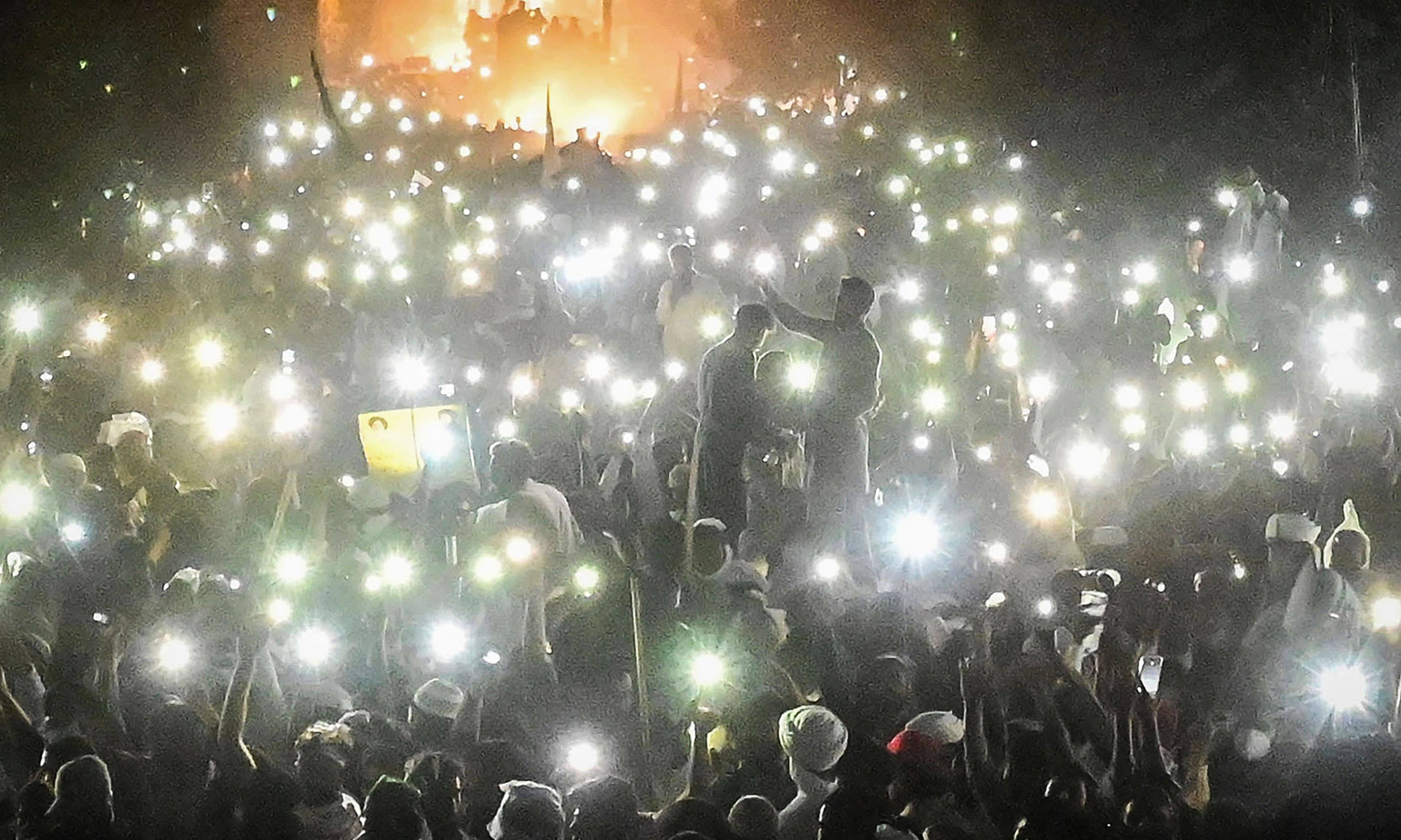 TLP supporters use mobile phone flashlights during a protest march towards Islamabad from Lahore on October 22. — AFP