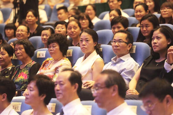 Yang Huiyan, the chairwoman of Country Garden, in a blue seat amid rows of men and women at a conference. 