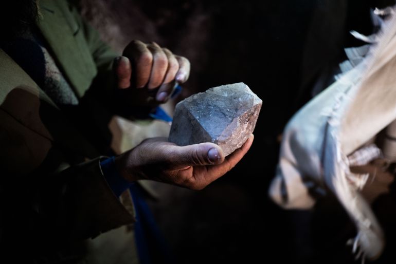 A miner in the pech valley shows a lump of quartz, which he says may indicate nearby stones of higher value