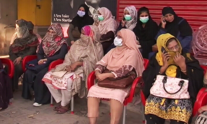 Women wait for their turn outside a polling station in Sindh’s Korangi area on Sunday.—DawnNewsTV