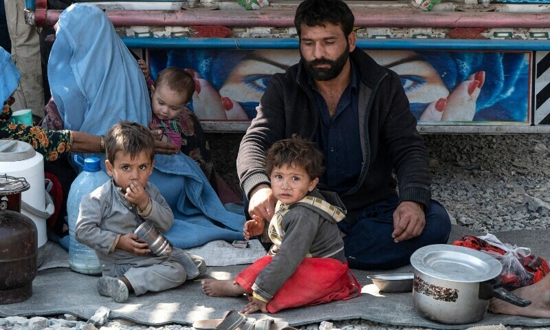 In this photo taken on October 30, Afghan refugees sit beside a truck on their arrival from Pakistan at the Afghanistan-Pakistan Torkham border in Nangarhar province. — AFP