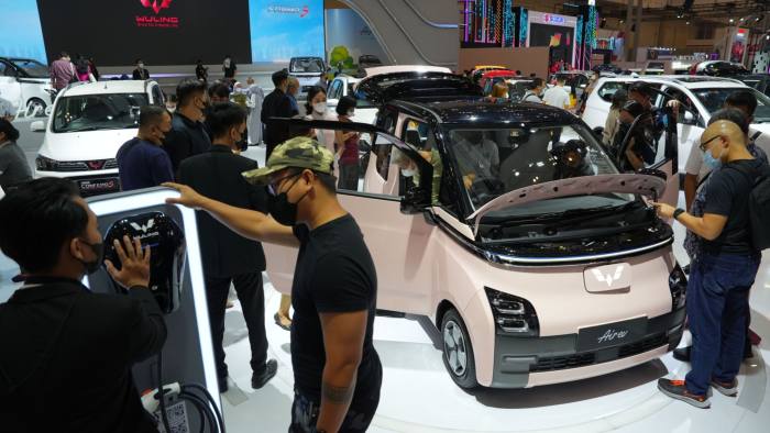 Visitors examine a Wuling Air electric vehicle, right, at the Gaikindo Indonesia International Auto Show in Tangerang, Indonesia
