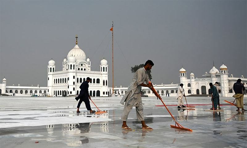 Workers clean the floor at the Shrine of Baba Guru Nanak Dev at the Gurdwara Darbar Sahib, ahead of its opening in Kartarpur. — AFP/File