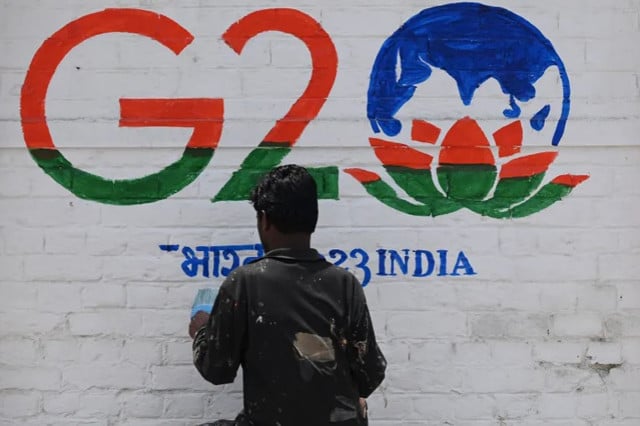 a man paints a wall with the g20 logo in the region s main city of srinagar photo afp