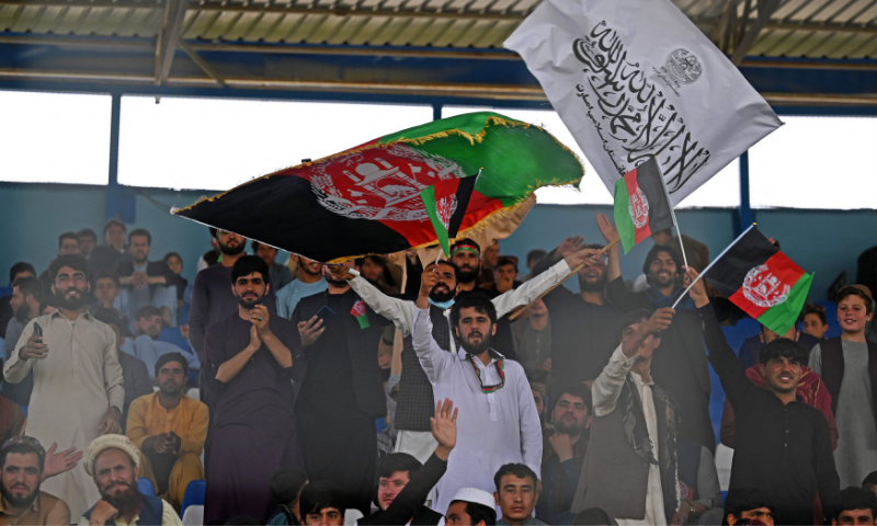 Spectators wave Afghanistan's and Taliban flags as they watch the Twenty20 cricket trial match being played between two Afghan teams 'Peace Defenders' and 'Peace Heroes' at the Kabul International Cricket Stadium in Kabul on Friday. — Photos from AFP
