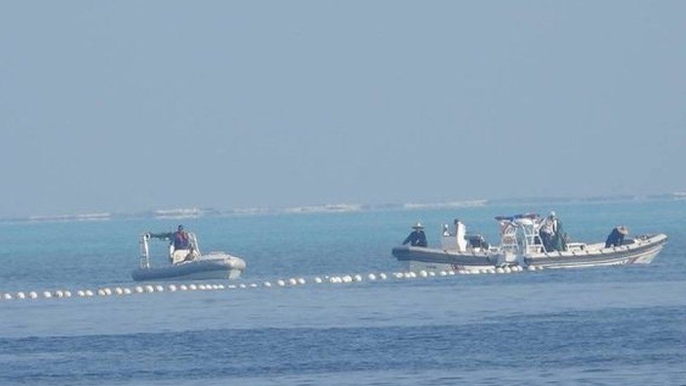Chinese coast guard boats close to the floating barrier are pictured near the Scarborough Shoal