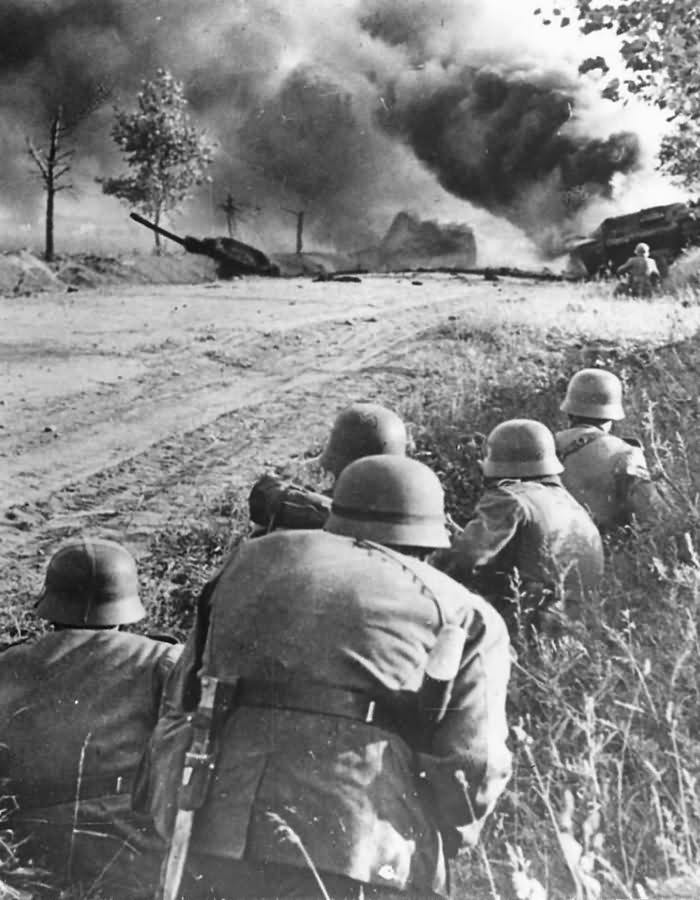 German_Soldiers_and_Burning_Soviet_Tank_on_Eastern_Front_1941.jpg