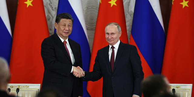 Russian President Vladimir Putin, right, and Chinese President Xi Jinping shake hands in Moscow on Tuesday, March 21. The Kremlin said on Wednesday that the West's reaction to Xi's visit has been hostile.