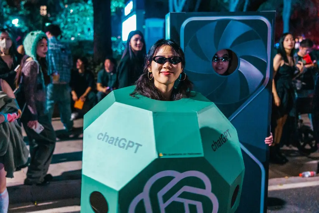 A person dressed in a geometric cuboid with chatGPT printed in large letters on the side.