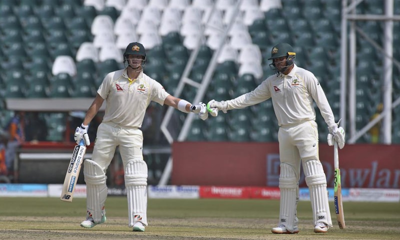 Australia's Steve Smith, left, bombs his fist with Usman Khawaja after hitting a boundary on the first day of the third test match between Pakistan and Australia at the Gaddafi Stadium in Lahore. — AP