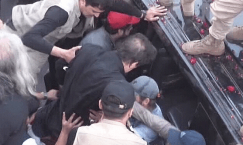 PTI Chairman Imran Khan being taken inside his vehicle on November 3 after he was injured in firing during the party's long march. —DawnNewsTV/File