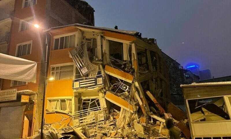 <p>A man walks past by a collapsed building after an earthquake in Malatya, Turkiye, February 6. — Reuters</p>