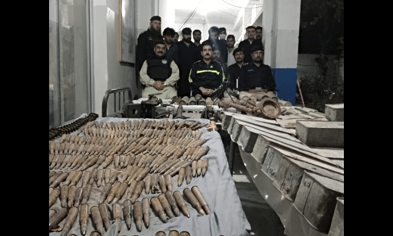 <p>Kohat police officials pose alongside the arms and ammunitions seized by them on May 3, 2023. — Photo provided by author</p>