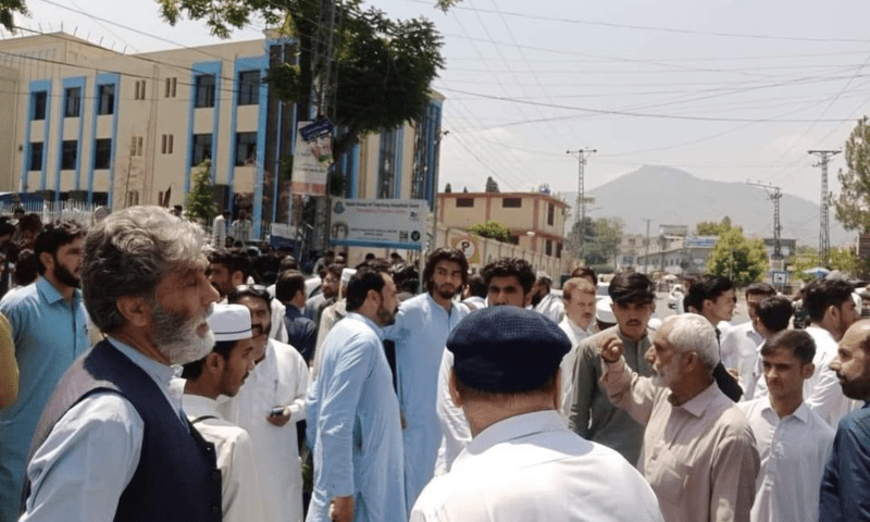  Bereaved families of those martyred and Mingora residents protest near the city’s Saidu Sharif road on Thursday, demanding the suspects behind the attack on policemen to be arrested. — Photo by Fazal Khaliq 