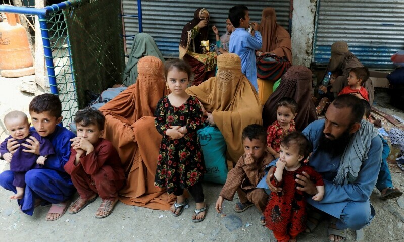  Muhammad Ismail, 40, sits with his family while they are waiting to cross main Afghanistan-Pakistan land border crossing, in Torkham, Pakistan on September 15. — Reuters