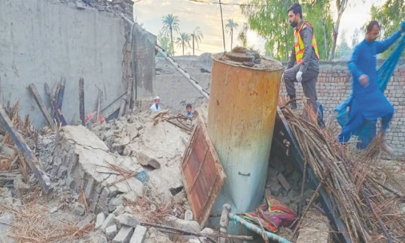 A rescue official examines the debris of a house that collapsed in Bannu on Friday. (Right) Mansehra-Naran-Jalkhad Road blocked by a landslide in Kawai area of Kaghan Valley. — Dawn