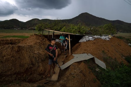 Armed Meitei community members stand behind a bunker as they keep watch on rival Kuki bunkers