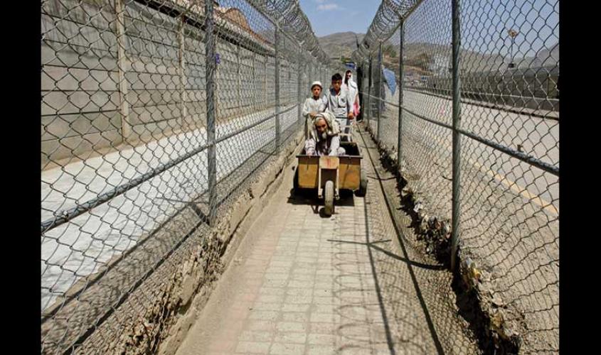 men coming from afghanistan move down a corridor between security fences at the border post in torkham pakistan on the durand line on 18 june 2016 photo reuters
