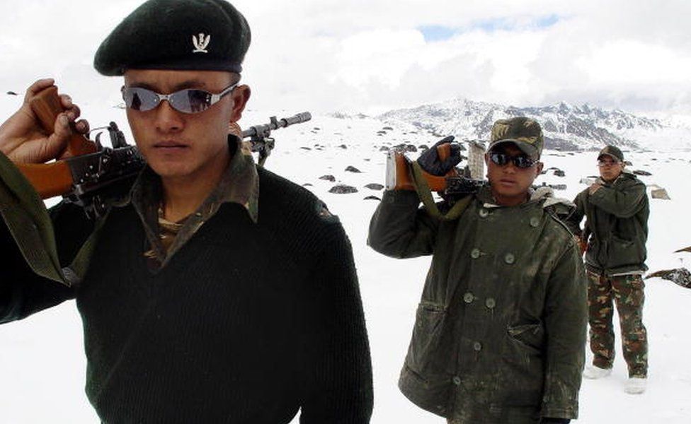 Indian Army soldiers of the Gorkha Regiment carry weapons as they walk through snow, along the India-China border at the height of 16,000ft near Tawang,some 580km from Itanagar, state capital of Arunachal Pradesh, 31 October 2003.
