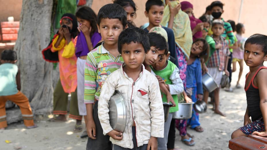 Children from a slum stand in queue to get free food after the government eased a nationwide lockdown as a preventive measure against the COVID-19 coronavirus, in New Delhi on June 15, 2020.