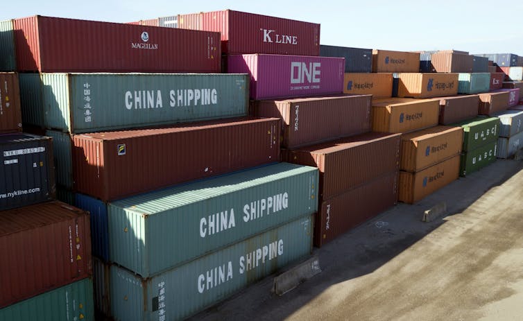 China Shipping Company and other shipping containers stacked at a terminal.