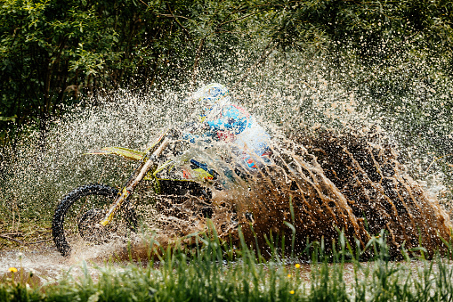 motorcycle-rider-crosses-puddle-splashes-of-water-and-dirt.jpg