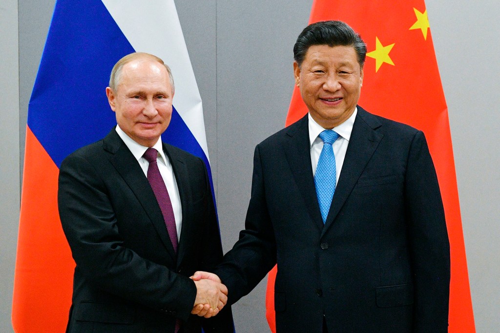 Russian President Vladimir Putin, left, and China's President Xi Jinping shake hands prior to their talks on the sideline of the 11th edition of the BRICS Summit, in Brasilia, Brazil in Nov. 12, 2019.