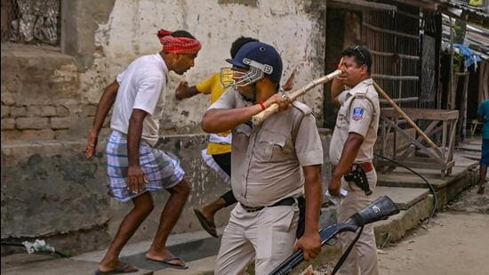 Police personnel baton charge after a clash between rival political groups during panchyat elections in Malda district of West Bengal on Saturday. (PTI)