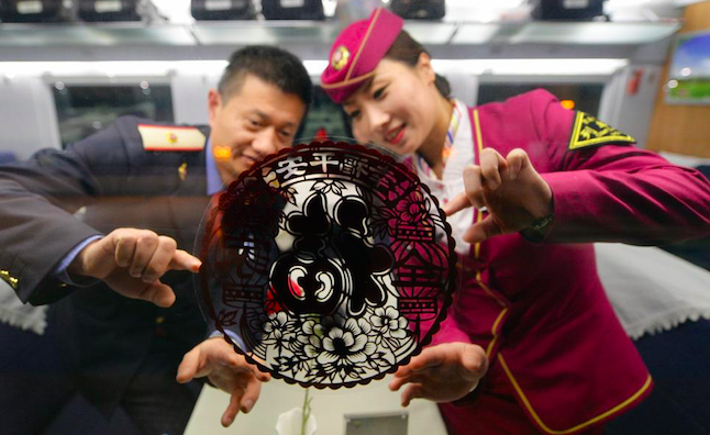 2015年2月10日，在北京南开往青岛的G177次列车上，列车长陈丽娟和餐车长王建飞正在张贴福字窗花.png