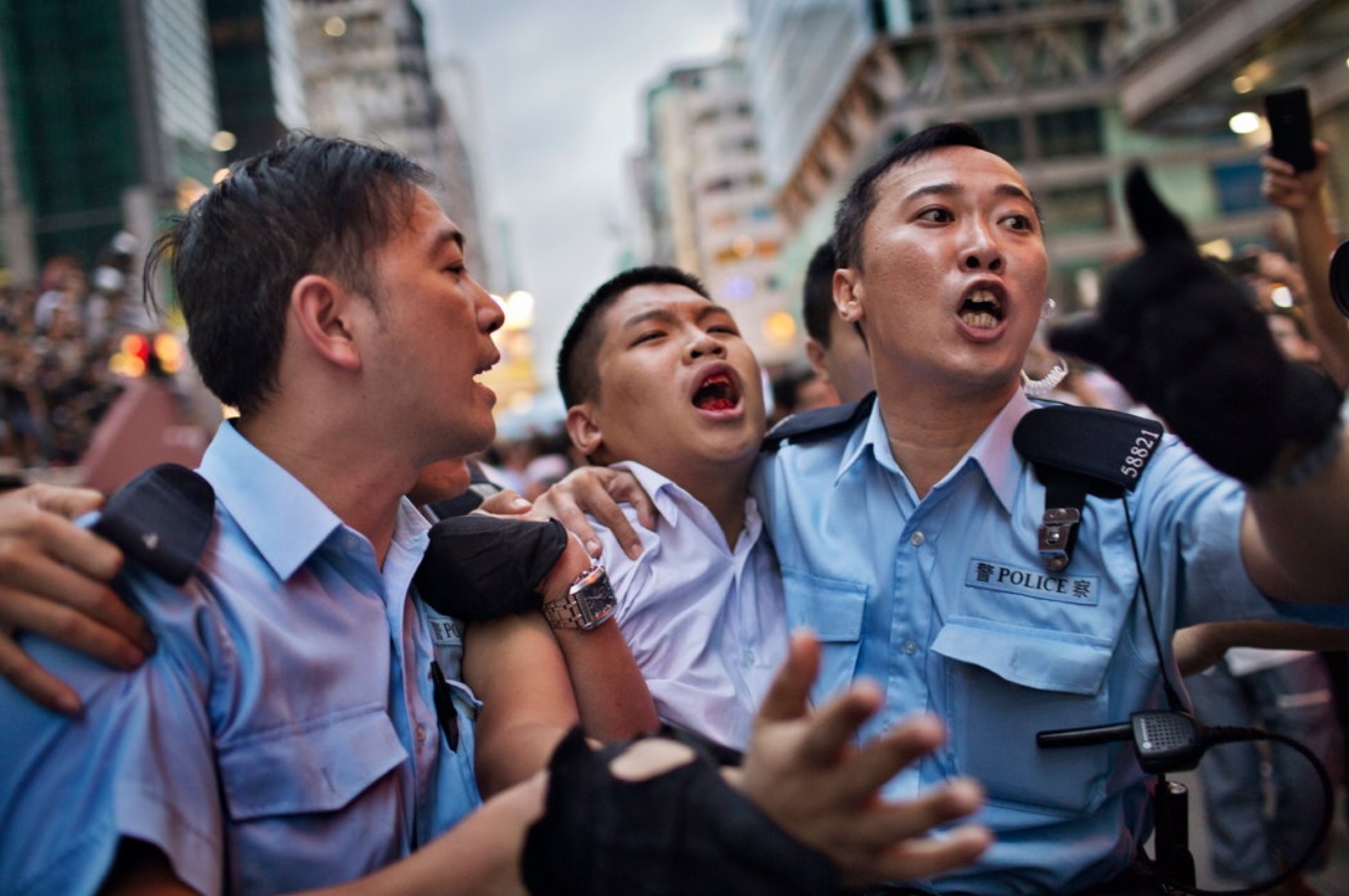 A pro-democracy protester being escorted by police officers in Mong Kok.jpg