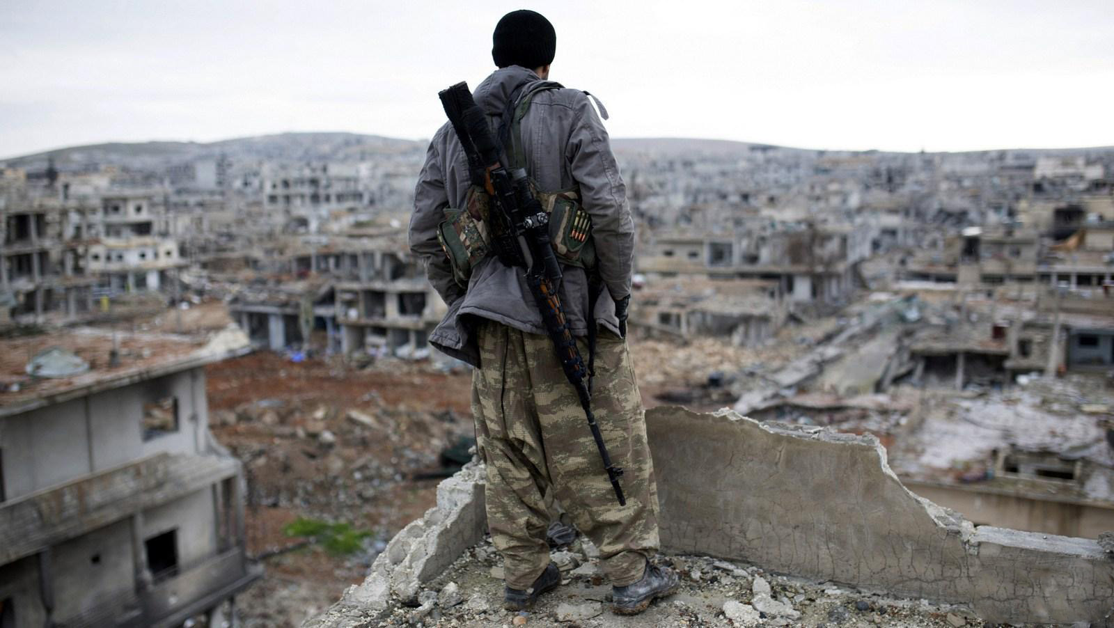 A Syrian rebel surveys the surrounding area.jpg