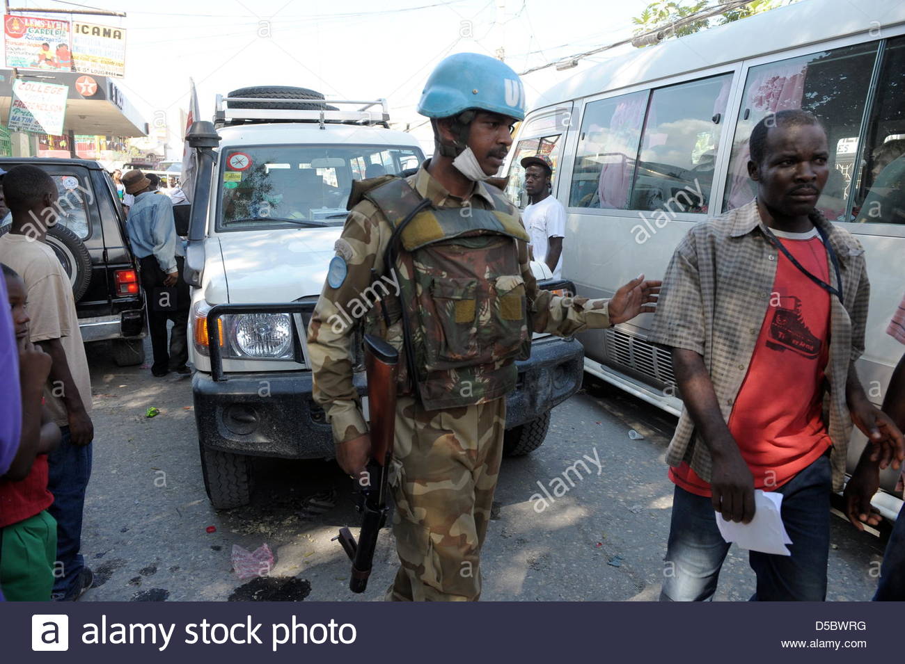 a-un-soldier-stands-guard-in-a-busy-street-in-port-au-prince-haiti-D5BWRG.jpg