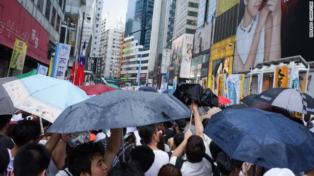 As rain begins to come down on the protesters, umbrellas fly open..jpg