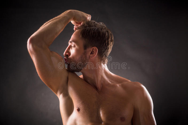 bodybuilder-s-biceps-kissing-his-over-dark-grey-background-short-haired-man-posing-his-eyes-cl...jpg