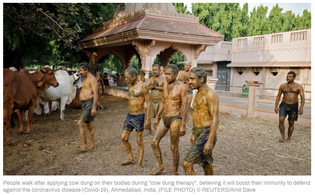 People walk after applying cow dung on their bodies during 'cow dung therapy', believing it wi...jpg