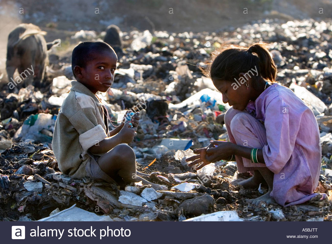 poor-indian-children-playing-with-toy-mobile-phone-whilst-sitting-A5BJTT.jpg