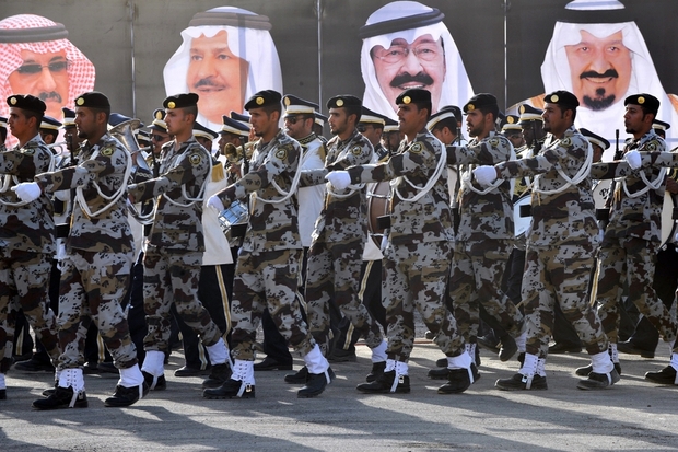 Saudi soldiers march past posters of royal family (AFP).jpg