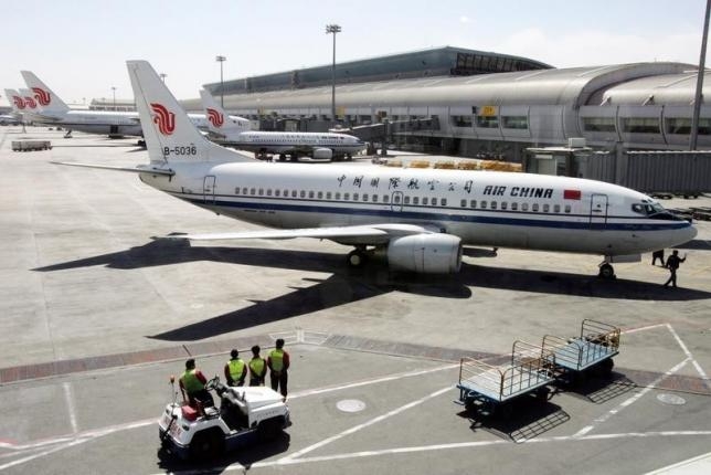 workers-stand-while-waiting-to-unload-cargo-from-an-airplane-in-beijing-airport.jpeg